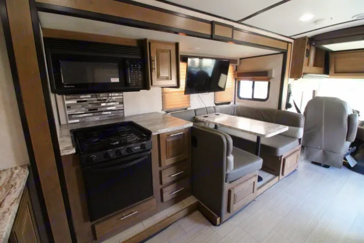 Galley kitchen with microwave, stove and oven